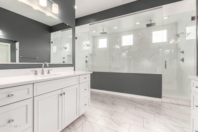 13850 W Weaver Ct, Litchfield Park, AZ 85340 - bathroom with plenty of natural light, a marble finish shower, vanity, marble look tiles, and recessed lighting