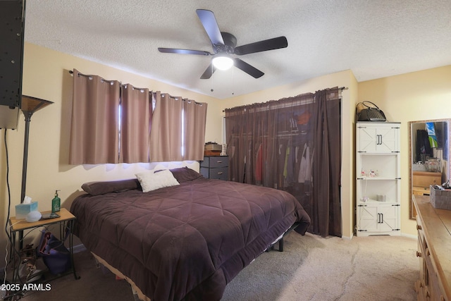 bedroom featuring ceiling fan, carpet floors, and a textured ceiling