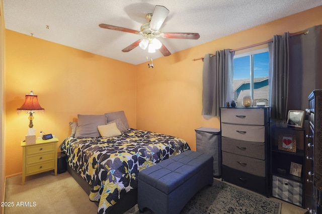 bedroom featuring ceiling fan, light colored carpet, and a textured ceiling