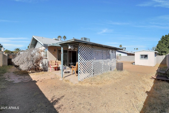 rear view of house featuring a storage shed and a patio