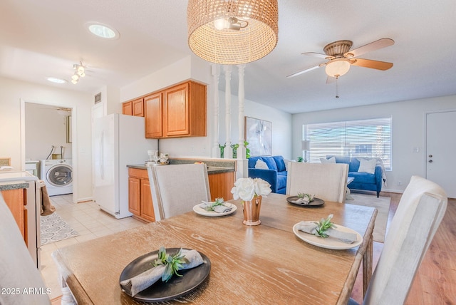 dining area featuring ceiling fan, light tile patterned flooring, a textured ceiling, and washer / clothes dryer