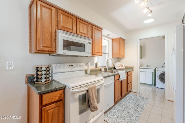 kitchen featuring washer / clothes dryer, light tile patterned floors, sink, and white appliances