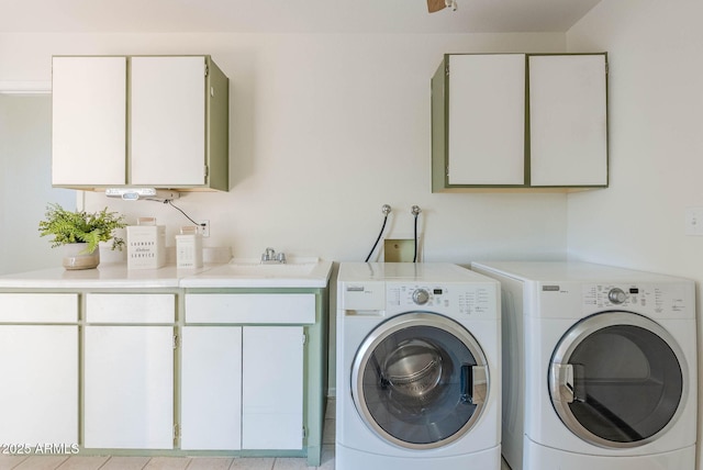 clothes washing area with cabinets, washer and dryer, and sink