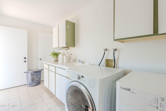 laundry room featuring cabinets, light tile patterned floors, sink, and washing machine and clothes dryer