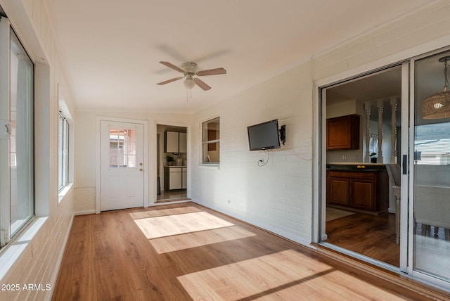 unfurnished sunroom featuring ceiling fan