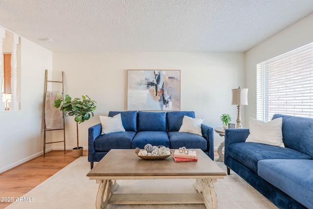 living room with a textured ceiling and light wood-type flooring