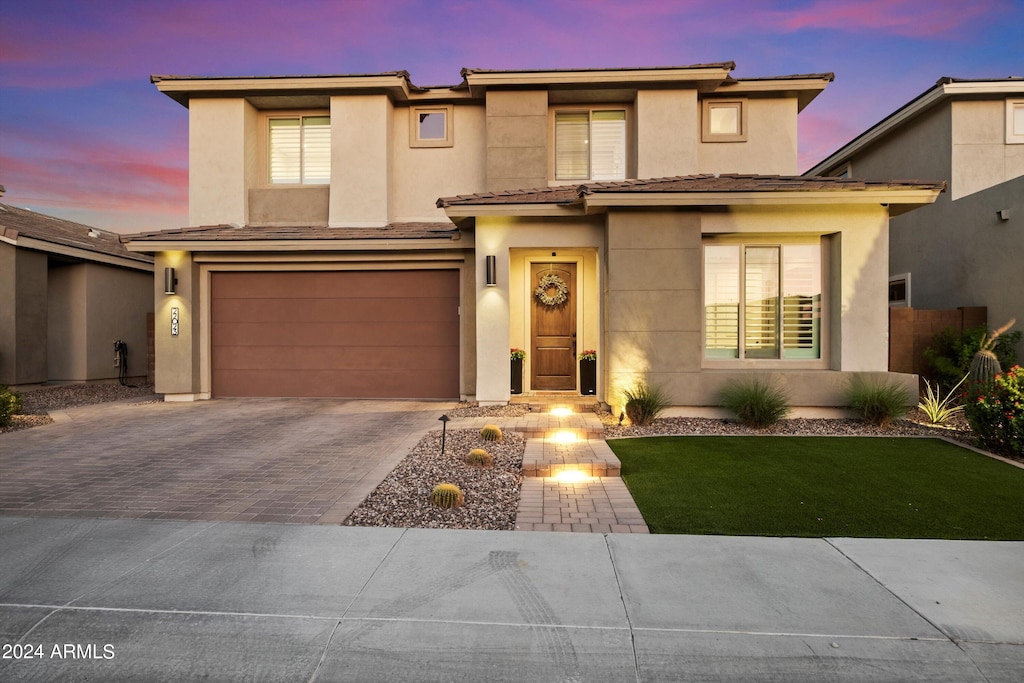 view of front of home with a garage and a yard