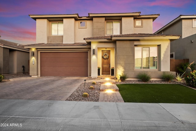 view of front of home with a garage and a yard