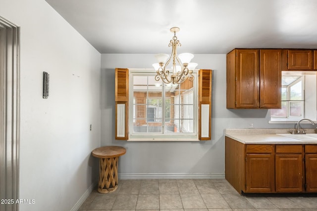 3001 N 21st Ave, Phoenix, AZ 85015 - kitchen featuring a sink, a chandelier, light countertops, brown cabinets, and baseboards