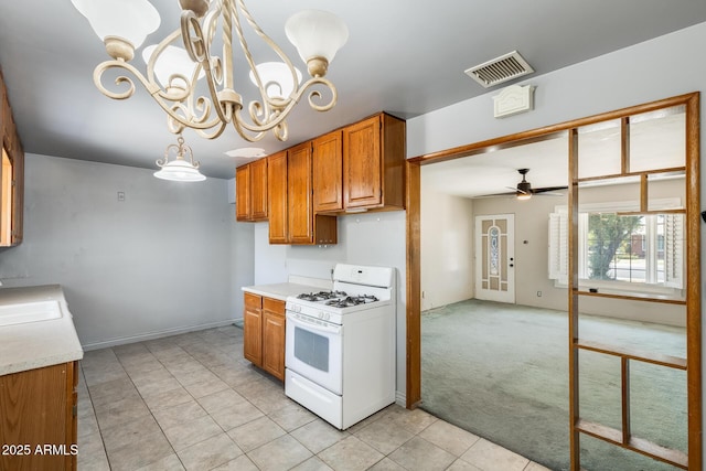 3001 N 21st Ave, Phoenix, AZ 85015 - kitchen featuring gas range gas stove, ceiling fan, a chandelier, light countertops, and brown cabinets