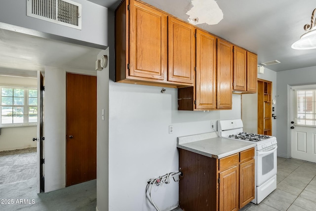 3001 N 21st Ave, Phoenix, AZ 85015 - kitchen with white range with gas cooktop, light countertops, plenty of natural light, and brown cabinetry
