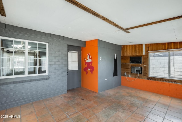 3001 N 21st Ave, Phoenix, AZ 85015 - unfurnished living room with plenty of natural light, wood walls, stone finish floors, and brick wall
