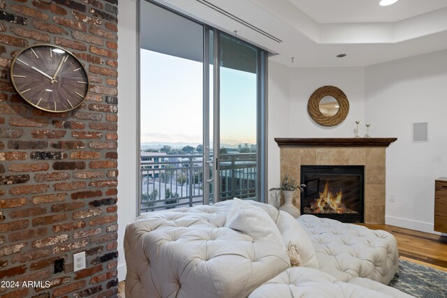 bedroom with access to exterior, hardwood / wood-style flooring, and brick wall