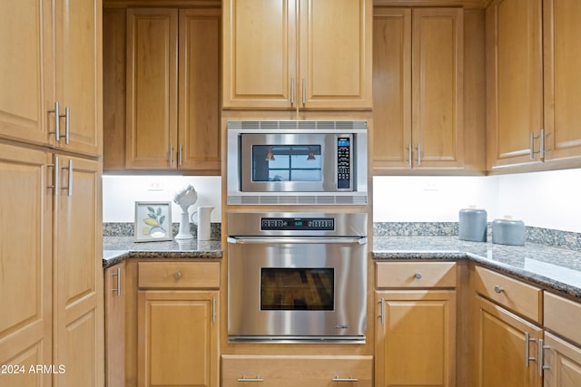 kitchen with stone countertops and appliances with stainless steel finishes