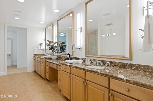 bathroom with tile patterned floors, vanity, and a tile shower