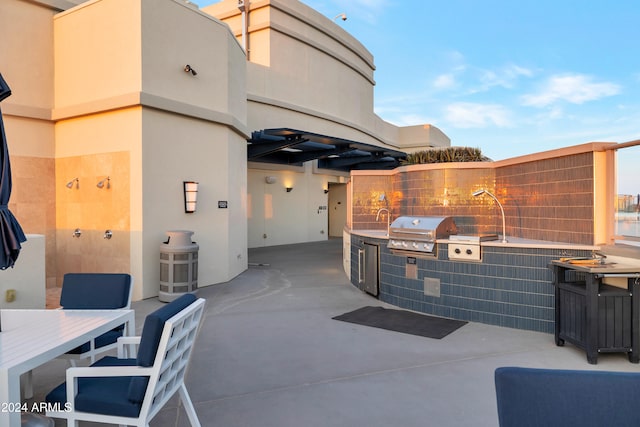 view of patio / terrace featuring an outdoor kitchen, area for grilling, and sink