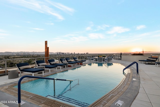 pool at dusk featuring a patio area