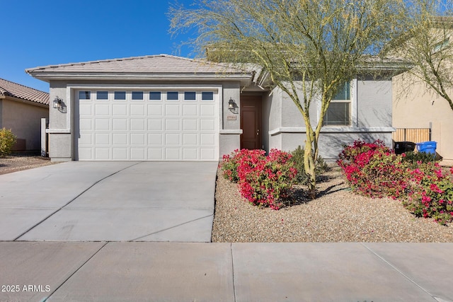 view of front of property with concrete driveway, an attached garage, and stucco siding