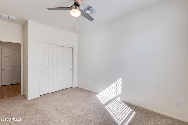 unfurnished bedroom featuring a closet, carpet flooring, visible vents, and baseboards