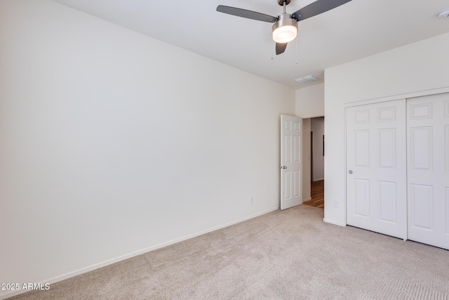 unfurnished bedroom with a closet, carpet, a ceiling fan, and baseboards