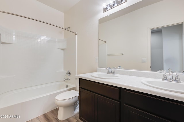 bathroom featuring a sink, shower / bathing tub combination, toilet, and double vanity