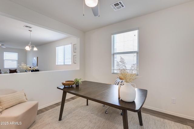 home office with a healthy amount of sunlight, visible vents, and wood finished floors