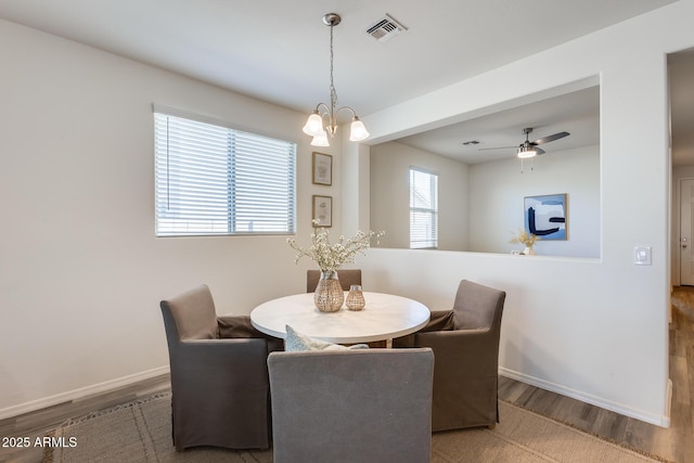 dining room featuring ceiling fan, wood finished floors, visible vents, and baseboards