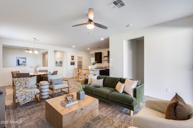 living room with recessed lighting, visible vents, and ceiling fan with notable chandelier