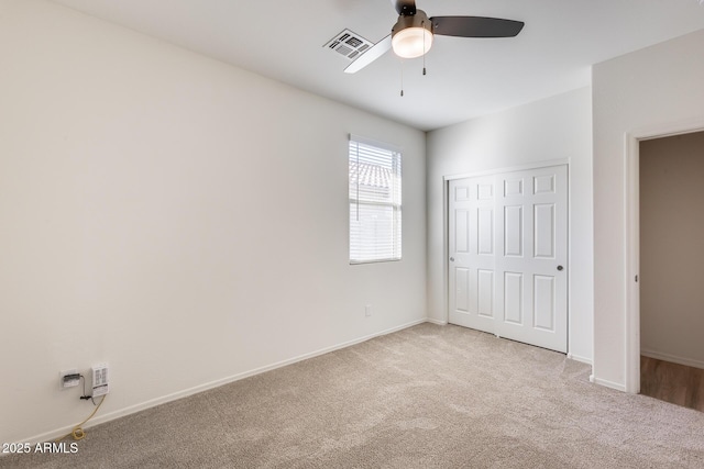 unfurnished bedroom with carpet, a closet, visible vents, and baseboards