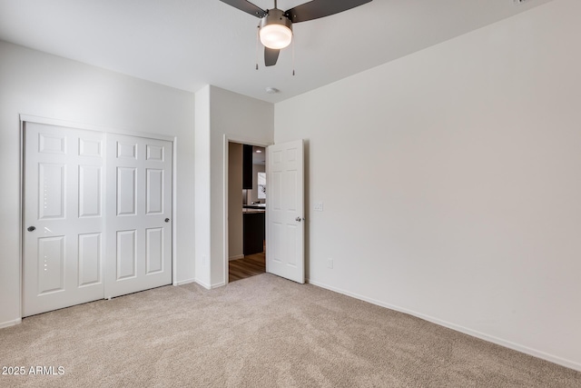 unfurnished bedroom with a closet, carpet flooring, and baseboards