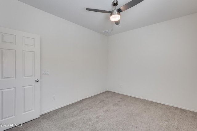 spare room with ceiling fan, carpet flooring, visible vents, and baseboards