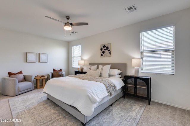 bedroom with baseboards, ceiling fan, visible vents, and light colored carpet