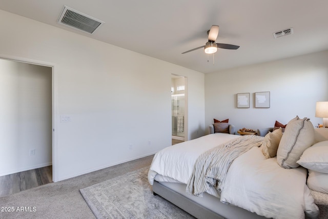 carpeted bedroom featuring ceiling fan, ensuite bath, visible vents, and baseboards