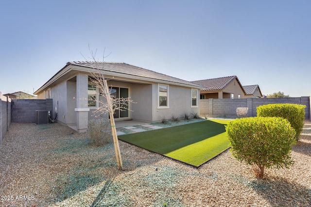 rear view of house with a patio, cooling unit, a fenced backyard, and stucco siding