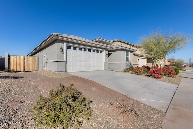 view of front of house featuring an attached garage, fence, concrete driveway, and stucco siding