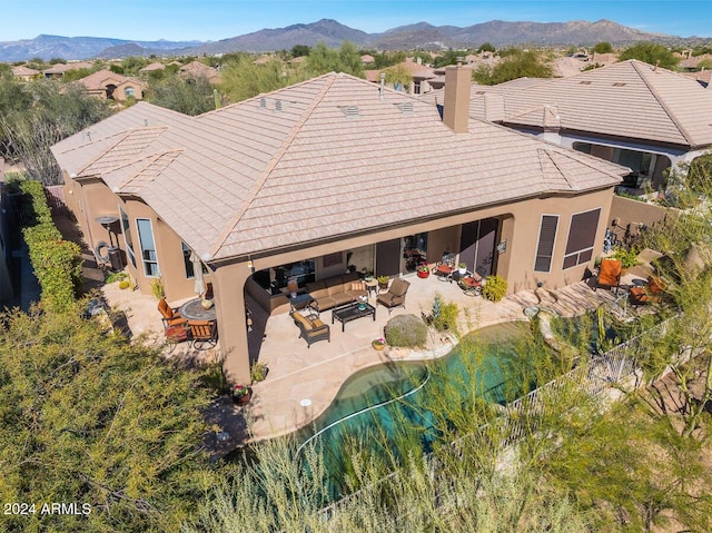 back of property featuring outdoor lounge area, a mountain view, and a patio area