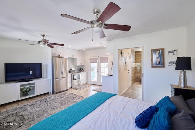 bedroom with light wood-type flooring, recessed lighting, a sink, and freestanding refrigerator