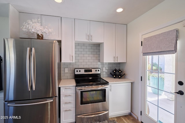 kitchen featuring white cabinets, stainless steel appliances, and light countertops