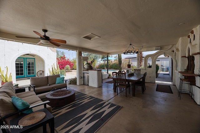 view of patio with french doors, an outdoor living space with a fire pit, outdoor dining space, ceiling fan, and an outdoor pool