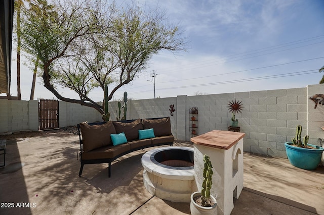 view of patio / terrace with a gate, a fenced backyard, and a fire pit