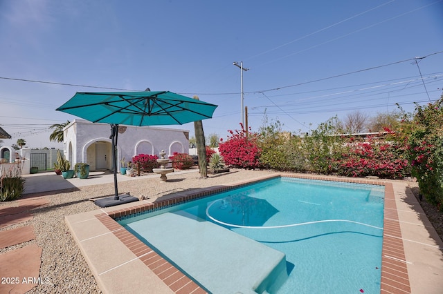 view of swimming pool featuring a patio area and fence