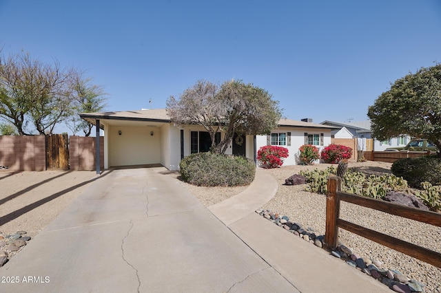 single story home featuring fence and concrete driveway