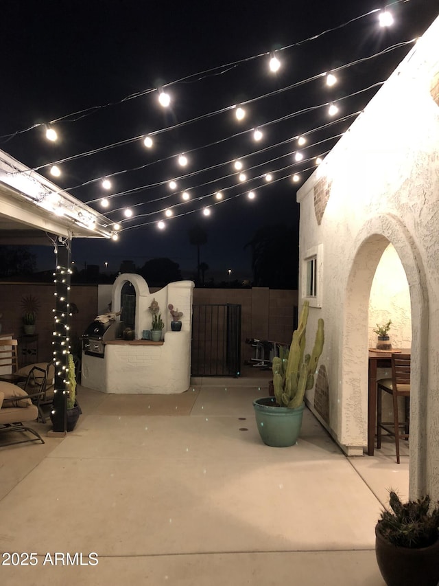 patio at night featuring fence