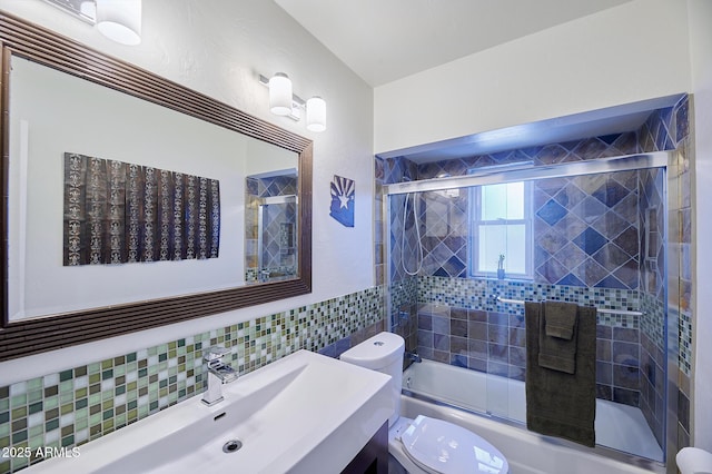 bathroom featuring shower / bath combination with glass door, tile walls, toilet, and vanity