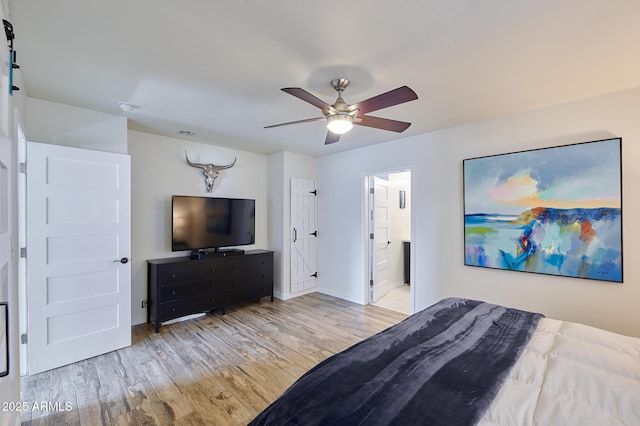 bedroom with visible vents, connected bathroom, ceiling fan, wood finished floors, and baseboards