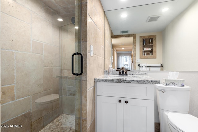 bathroom featuring vanity, toilet, and a shower with shower door