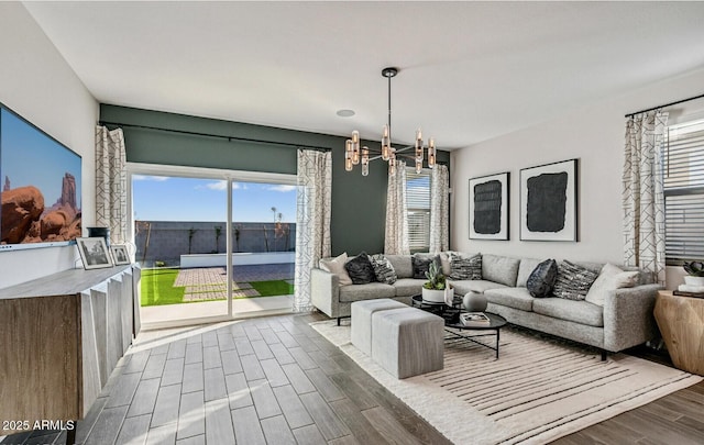 living area with wood finished floors and a notable chandelier