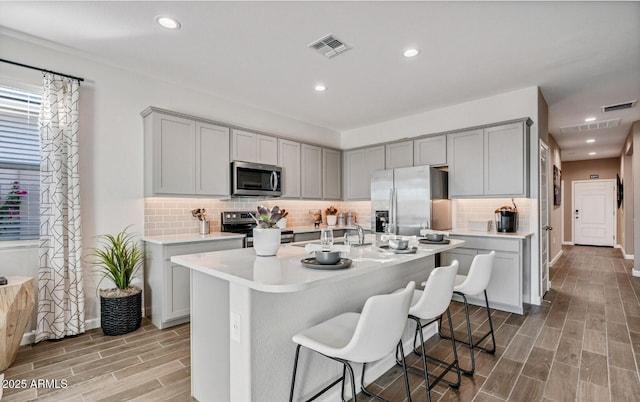 kitchen with appliances with stainless steel finishes, gray cabinets, and visible vents