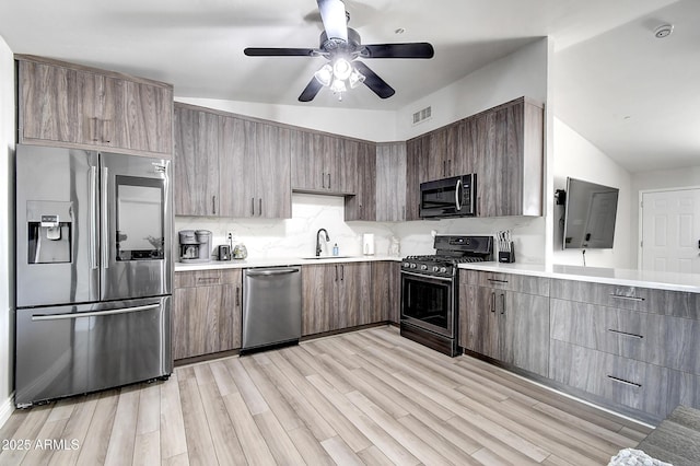 kitchen featuring light countertops, visible vents, appliances with stainless steel finishes, a sink, and light wood-type flooring