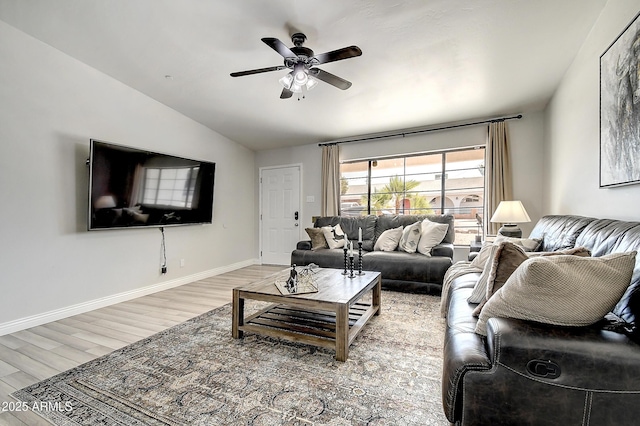 living room with lofted ceiling, a ceiling fan, light wood-style flooring, and baseboards